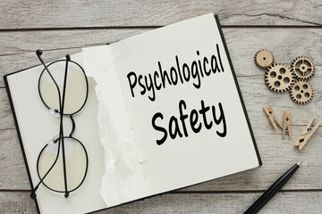 glasses on an open notepad. text on page PSYCHOLOGICAL SAFETY -