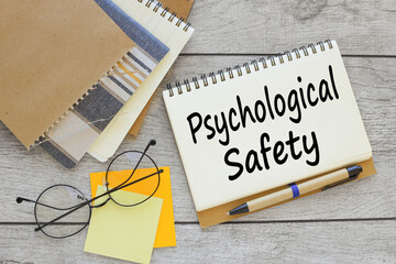 text on a notepad with a spring near a sticker with text PSYCHOLOGICAL SAFETY
