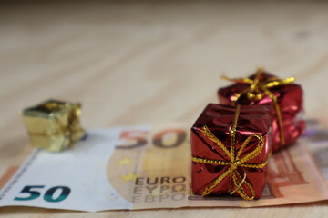 Pacchetto regalo con fiocco rosso sul denaro in Euro. - obrazy, fototapety, plakaty