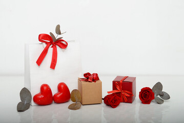 Gift bag, boxes with bow, preserved roses, hearts isolated on white.Holiday gifts, shopping. Store...