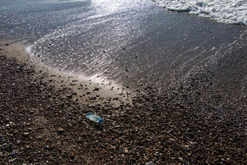 empty water bottle thrown on the beach