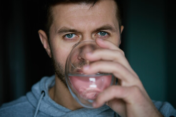 Man drinks water, Close-up shot of bearded man drinking fresh clean water from glass, Quenching...