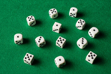 Aerial view of white dice on green mat, horizontal, with copy space