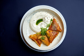 Ukrainian fried pancakes filled with meat served with sour cream. Restaurant photo for menu. Crepes with meat