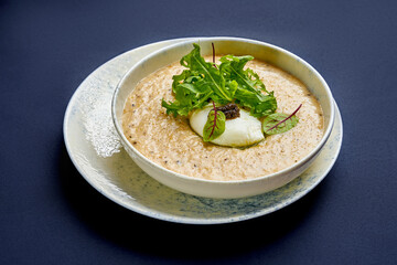 Oat porridge with truffle paste and poached egg. Breakfast oatmeal