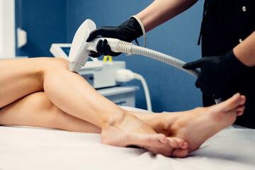 Hair removal cosmetology procedure from a therapist at cosmetic beauty spa clinic. Laser epilation...