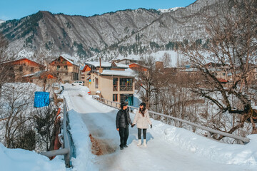 A couple walks in Mestai, a rural village in northern Georgia. In the winter covered with snow.