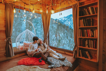 A couple enjoys a beautiful morning view of snow in a glass room at their winter home in Georgia. - Powered by Adobe