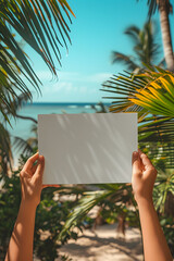Hands holding showing blank white empty paper board frame billboard sign on the beach at summer for ad advertising with copy space for text, travel vacation business announcement promotion concept