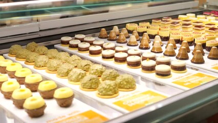 Rows of gourmet sweet cream cakes presented in delicatessen patisserie SLIDE SHOT