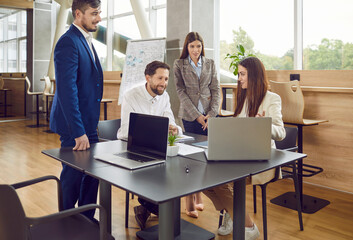 Business people team around a table for an engaging meeting and training session. Professional group work captures the synergy of communication, showcasing the exchange of ideas in the office.