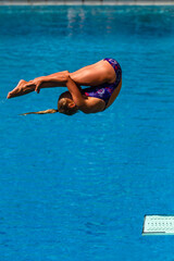 Girl Diver Somersault Diving Action Over Swimming Pool Closeup Photograph.