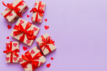 Top view photo of valentine day decorations gift box with red ribbon bow on colored background. Holiday gift boxes with top view