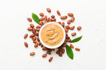 Bowl of peanut butter and peanuts on table background. top view with copy space. Creamy peanut...