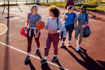 Naklejka premium Diverse group of young woman walking on basketball court preparing to play.