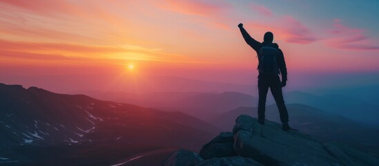 Silhouette of businessman celebrating raising arms on the top of mountain with over sunset sky and sunlight.concept of leadership successful achievement with goal,growth,up,win and objective target.