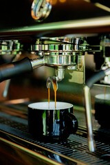 Close-up of espresso pouring from coffee machine - stock photo