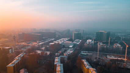 Foggy sunrise with San Donato Milanese skyline from a drone, Lombardia, Milano, Italia 4.02.2024