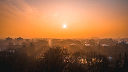 Foggy sunrise with San Donato Milanese skyline from a drone, Lombardia, Milano, Italia 4.02.2024