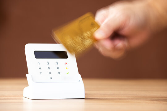 Mobile Point of sale (POS) or electronic credit and debit card reader with the action of approaching a bank card to process the transaction
