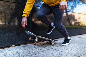 Close up on legs and skateboard of man skating in city. Stylish skateboarder training in skate park. Concept of skateboarding as sport and lifestyle.