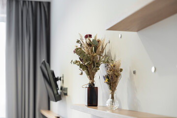 flowers in a vase on wooden shelves in the apartment