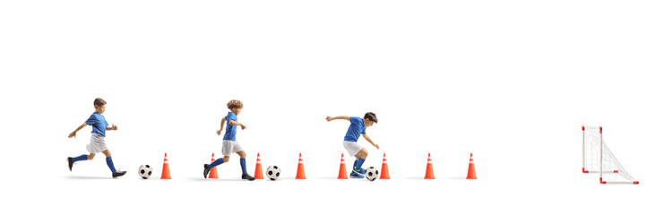 Naklejka premium Boys training football with cone obstacles, aguility and speed training