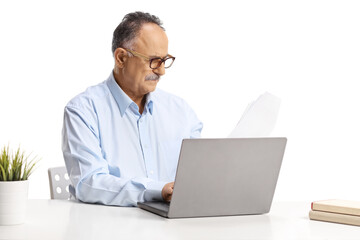 Mature man sitting at a desk and working on a laptop computer