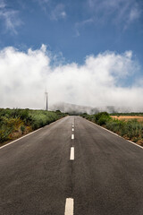 Road fades into misty hills.