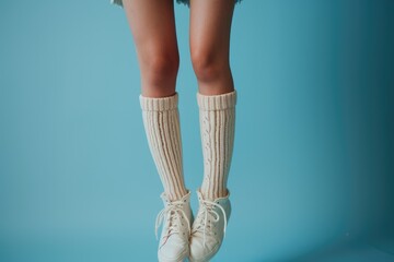 A person is pictured wearing white socks and white shoes. This image can be used to showcase fashion, footwear, or everyday clothing choices - obrazy, fototapety, plakaty