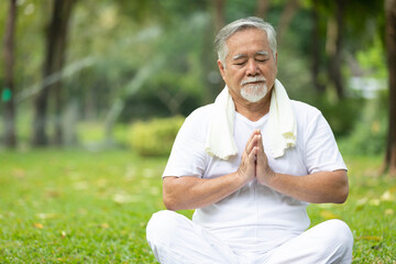 Naklejka na ściany i meble asian senior man meditating and doing yoga in the park