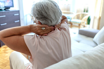 Unhealthy mature woman touching her head suffering from headache, migraine or dizziness. Age, medicine, health care and people concept.