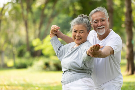 senior couple stretching before exercise and doing yoga in the park