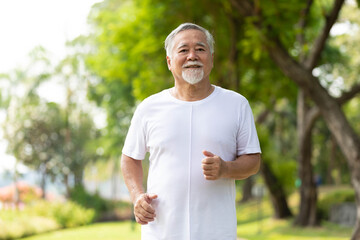 Naklejka na ściany i meble senior man running and exercising in the park