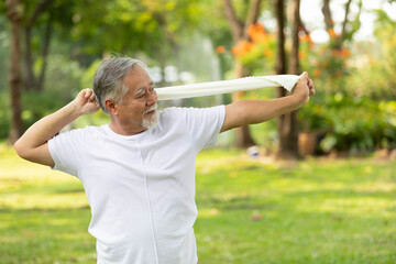 asian senior man workout and stretching with white towel in the park