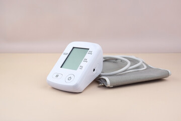 Digital blood pressure tonometer and pack of pills on a light background with copy space.