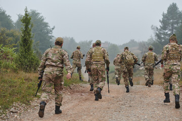 Fototapeta premium A disciplined and specialized military unit, donned in camouflage, strategically patrolling and maintaining control in a high-stakes environment, showcasing their precision, unity, and readiness for