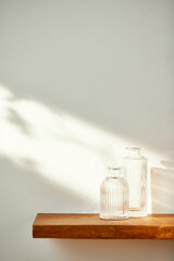 A water cup and shadow on a table in the sunlight.