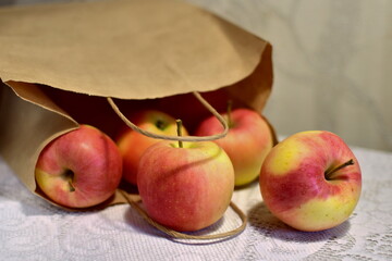apples on the table that rolled out of a paper bag