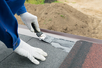 a worker covers the cracks with sealant on the roof © kurgu128