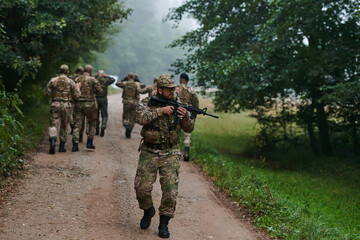 A group of elite soldiers leads captives through a military camp, showcasing a tense atmosphere of...