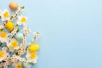 Festive background with spring flowers and Easter eggs, white daffodils and cherry blossom branches...