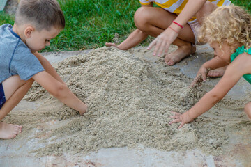 Children play with sand on the street. Selective focus.