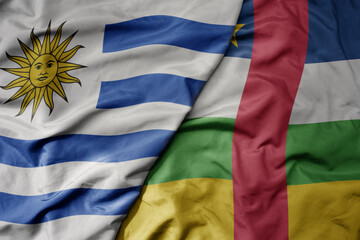 big waving national colorful flag of central african republic and national flag of uruguay .