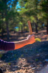 A determined man showcasing his skilled craftsmanship, holding a sturdy wooden rod, a testament to the artistry and dedication of handcrafted work