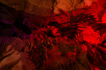 Journey through a vibrant cave adorned with colorful walls, stalactites, and stalagmites, revealing...