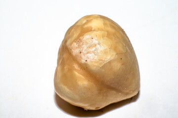 A captivating macro photo showcasing the natural beauty of a hazelnut against a pristine white background, highlighting its organic and healthy essence.
