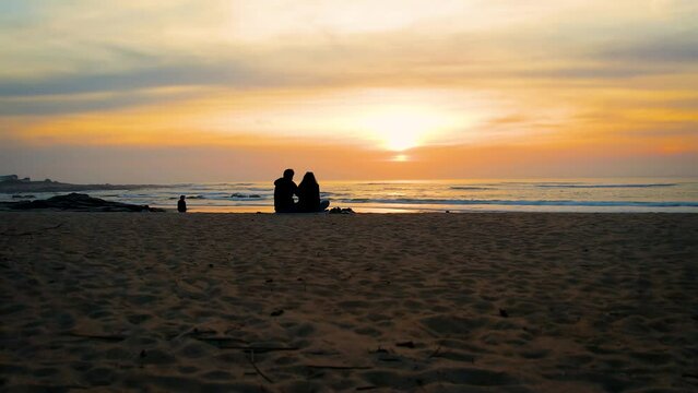 Romantic couple watching the sunset on the beach