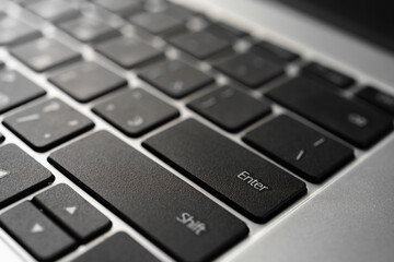 Laptop keyboard with black keys and aluminum metal case.
