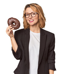 Caucasian middle-aged businesswoman with donut in studio